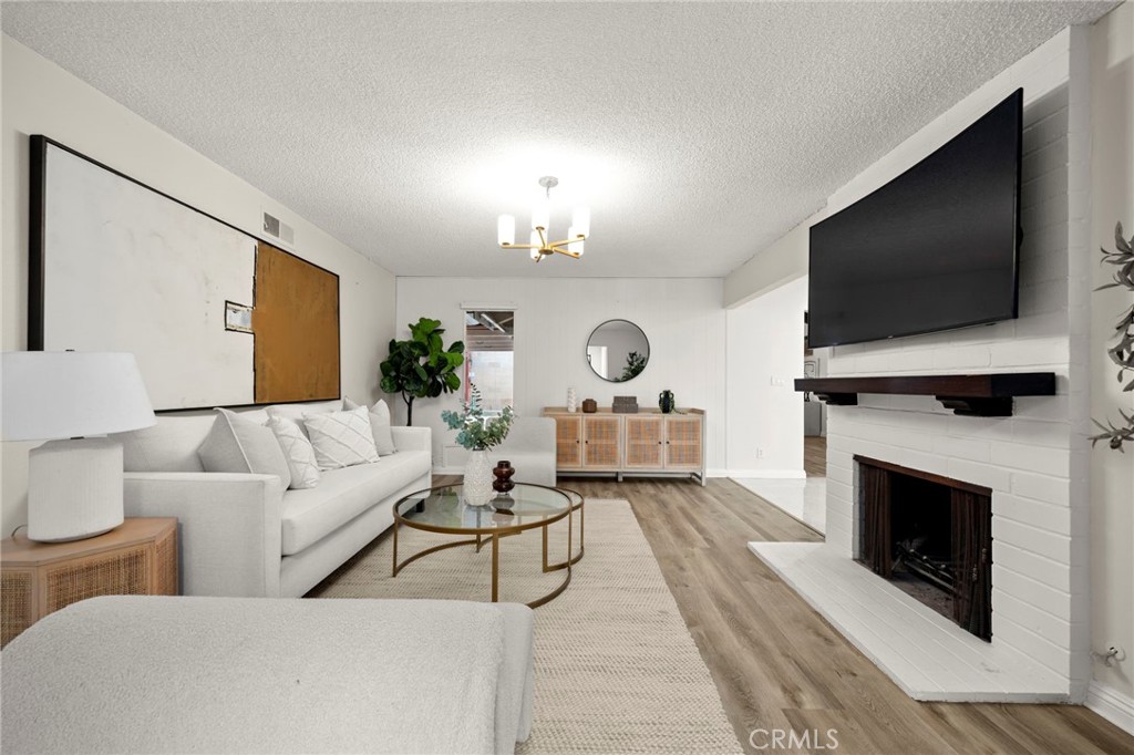12817 Meadow Green Road La Mirada, CA 90638 - Photo 7 of 43 a living room with furniture a flat screen tv and a fireplace
