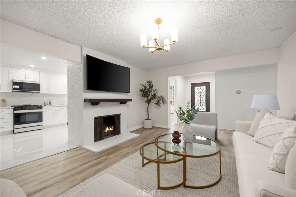 12817 Meadow Green Road La Mirada, CA 90638 - Photo 8 of 43 a living room with furniture a fireplace and a flat screen tv