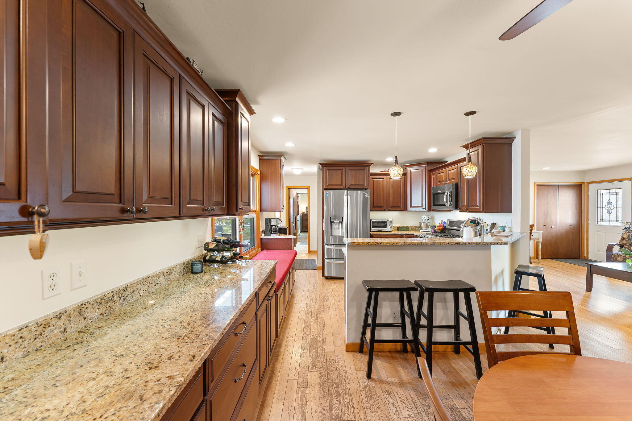 3910 West 106th Lane Crown Point, IN 46307 - Photo 6 of 31 a kitchen with stainless steel appliances granite countertop sink microwave and wooden floor