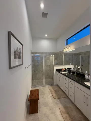 a bathroom with a double vanity sink a toilet and a mirror