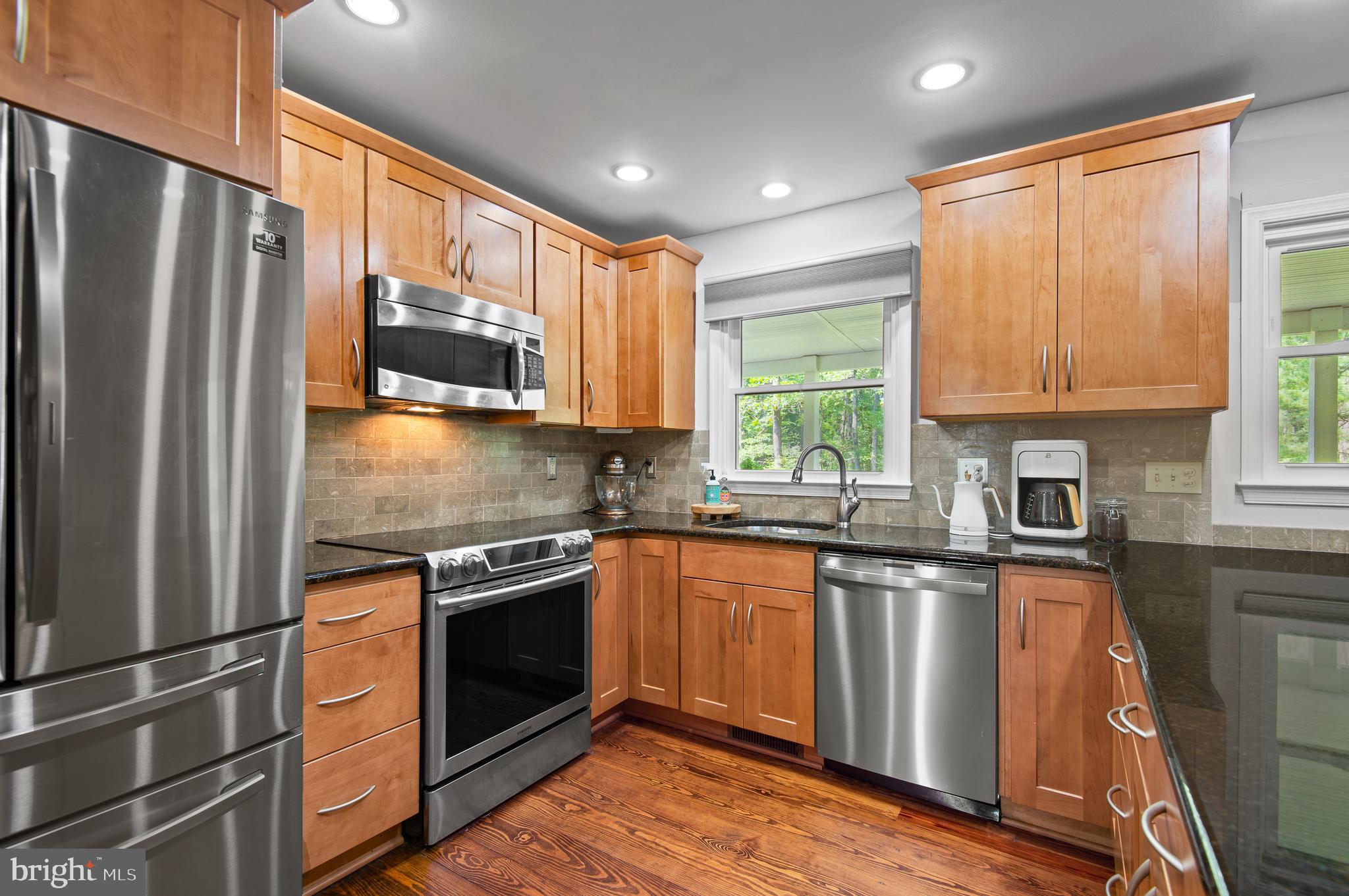 20000 Cameron Mill Road Parkton, MD 21120 - Photo 13 of 57 a kitchen with granite countertop stainless steel appliances and wooden cabinets