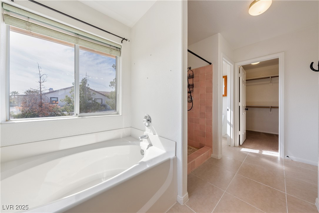 3581 Ranger Way Pahrump, NV 89048 - Photo 33 of 57 Primary Bathroom featuring tile patterned flooring, a shower stall, a bath, and baseboards