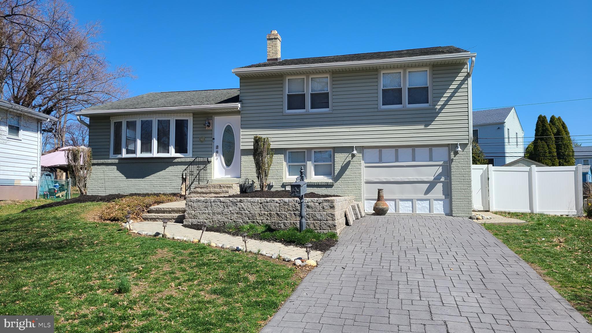 a front view of a house with garden and plants