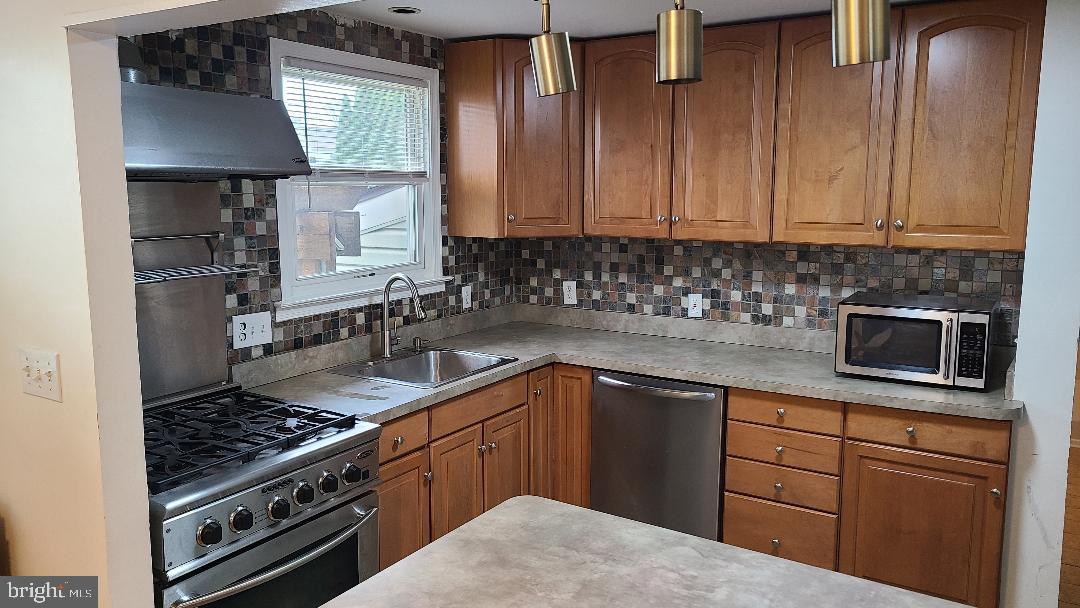 960 Dale Road Secane, PA 19018 - Photo 22 of 23 a kitchen with stainless steel appliances granite countertop a sink stove and cabinets