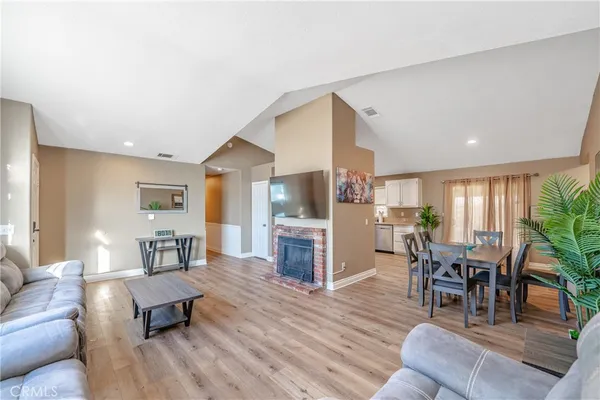 a living room with furniture flat screen tv and wooden floor