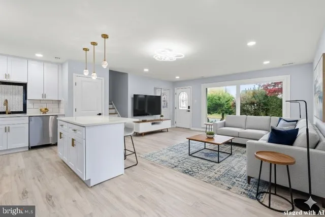 a kitchen with stainless steel appliances kitchen island hardwood floor sink stove and a window