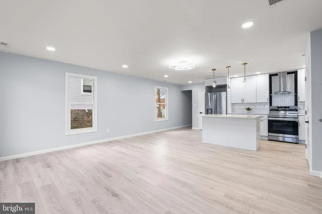a kitchen with kitchen island white cabinets and stainless steel appliances