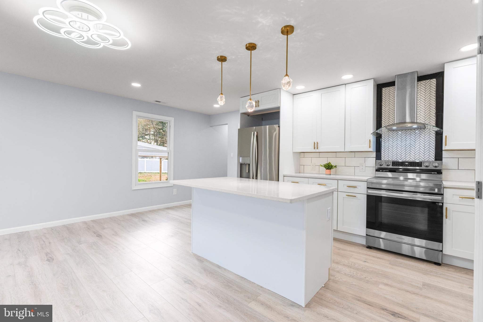 11046 Ferndale Street Philadelphia, PA 19116 - Photo 7 of 37 a kitchen with stainless steel appliances granite countertop a stove a sink dishwasher a refrigerator white cabinets and wooden floor