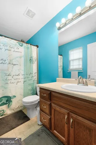 a bathroom with a sink a toilet a mirror and bathtub