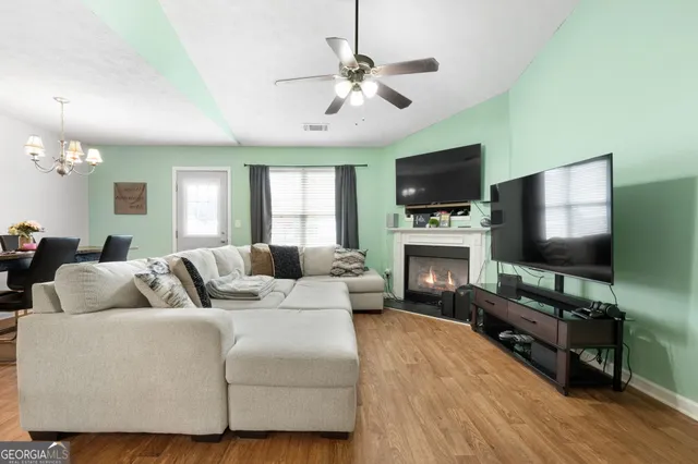 a living room with furniture a flat screen tv and a fireplace