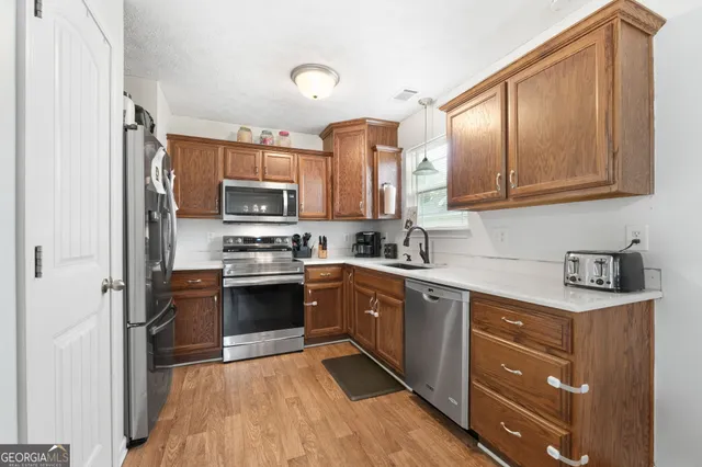 a kitchen with stainless steel appliances granite countertop a refrigerator and a stove top oven