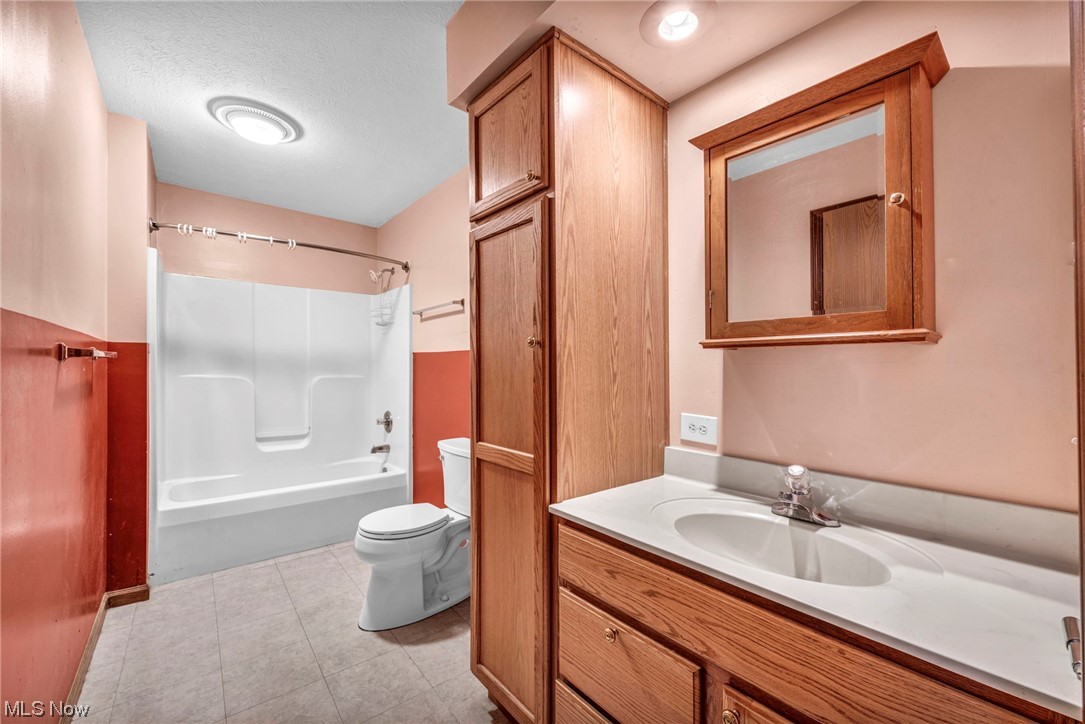 35808 Lorain Road North Ridgeville, OH 44039 - Photo 12 of 35 Full bathroom featuring vanity, bathtub / shower combination, toilet, a textured ceiling, and tile floors