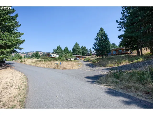 a view of a lake with beach and trees in the background
