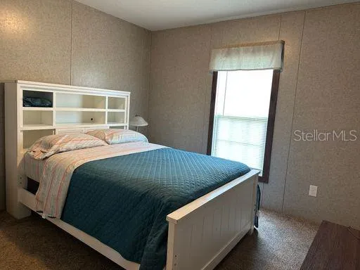 a bed sitting in a bedroom next to a window