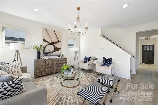 a living room with furniture and a chandelier