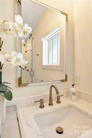 a bathroom with a granite countertop sink a large mirror and a shower