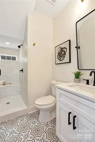 a bathroom with a sink a toilet and shower
