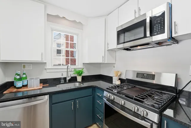 a kitchen with stainless steel appliances a stove a microwave sink and cabinets