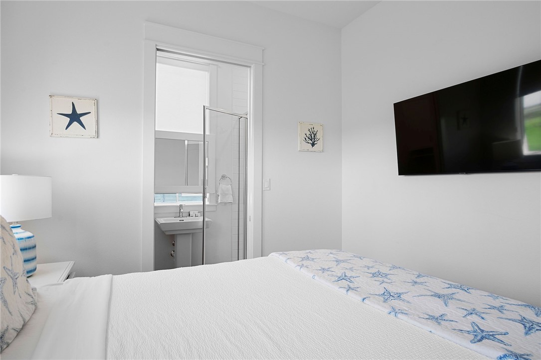 214 Sunset Avenue, Unit 2 Port Aransas, TX 78373 - Photo 15 of 37 a bedroom with a bed and a flat screen tv