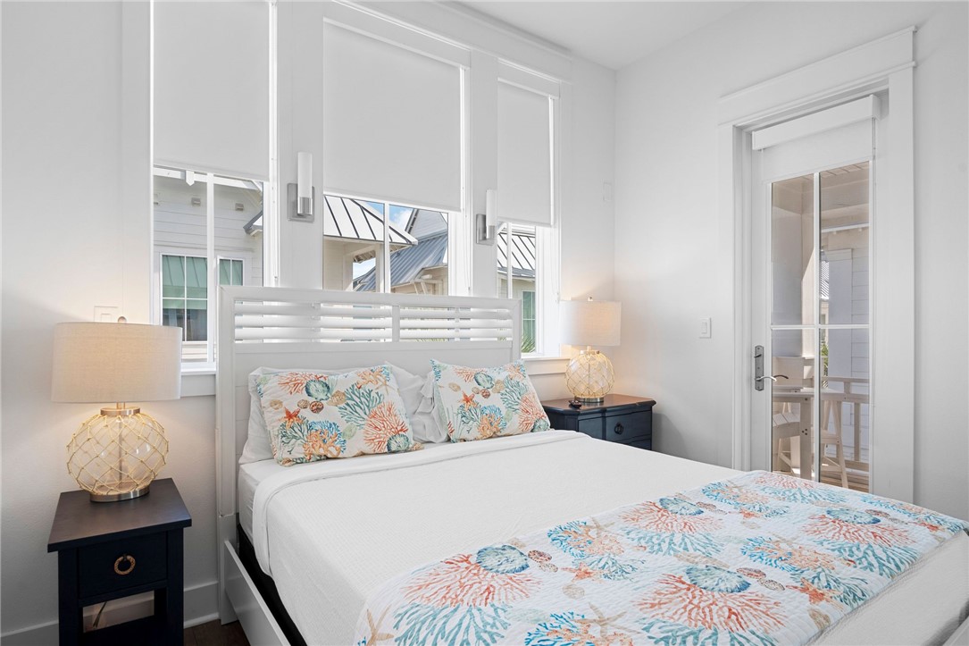 214 Sunset Avenue, Unit 2 Port Aransas, TX 78373 - Photo 17 of 37 a bedroom with a bed and wooden floor