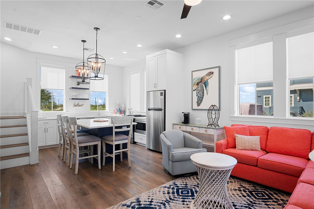 214 Sunset Avenue, Unit 2 Port Aransas, TX 78373 - Photo 8 of 37 a dining room with furniture a rug and a chandelier