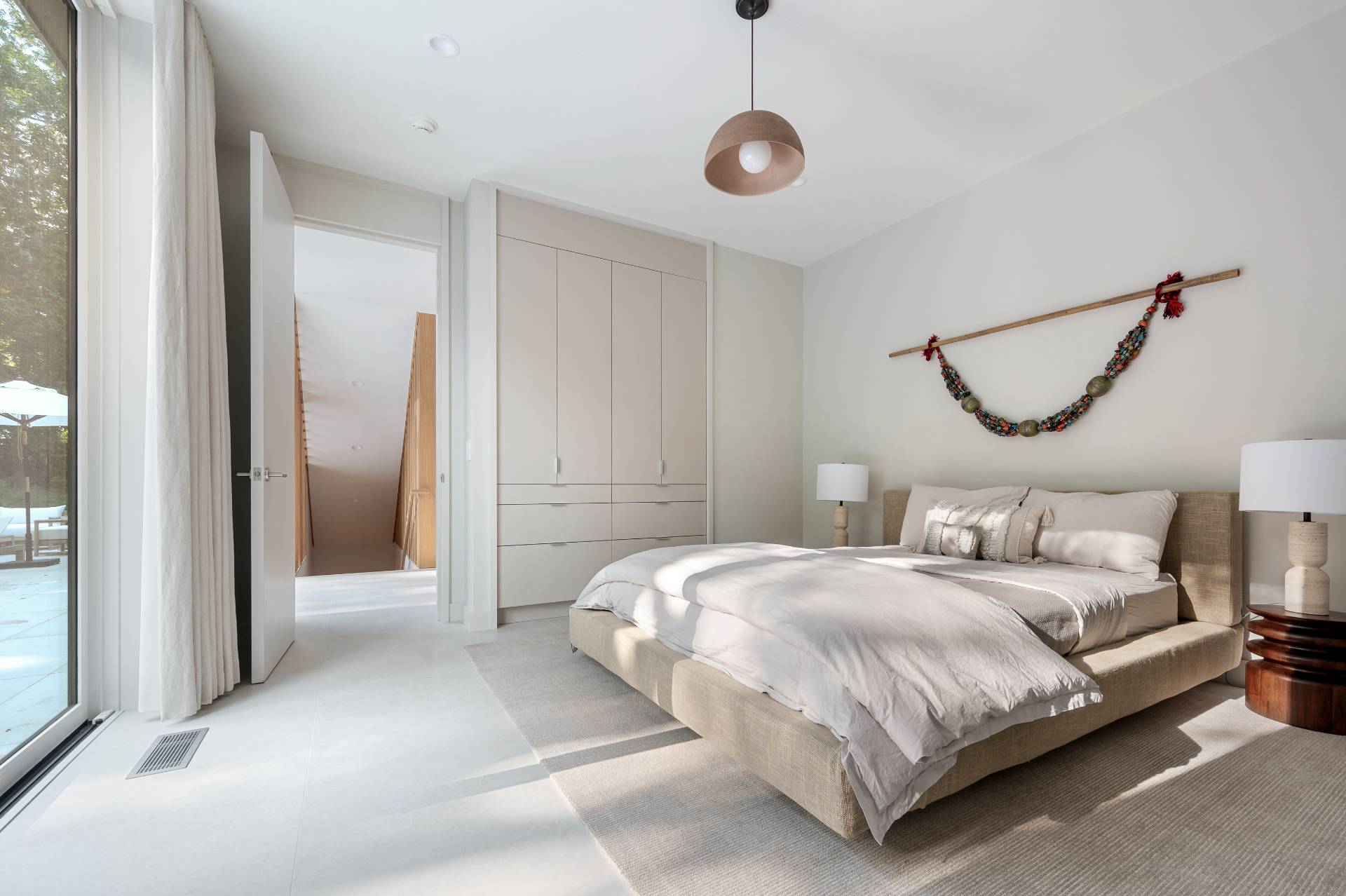 232 Kings Point Road East Hampton, NY 11937 - Photo 22 of 37 a bedroom with a bed and a chandelier