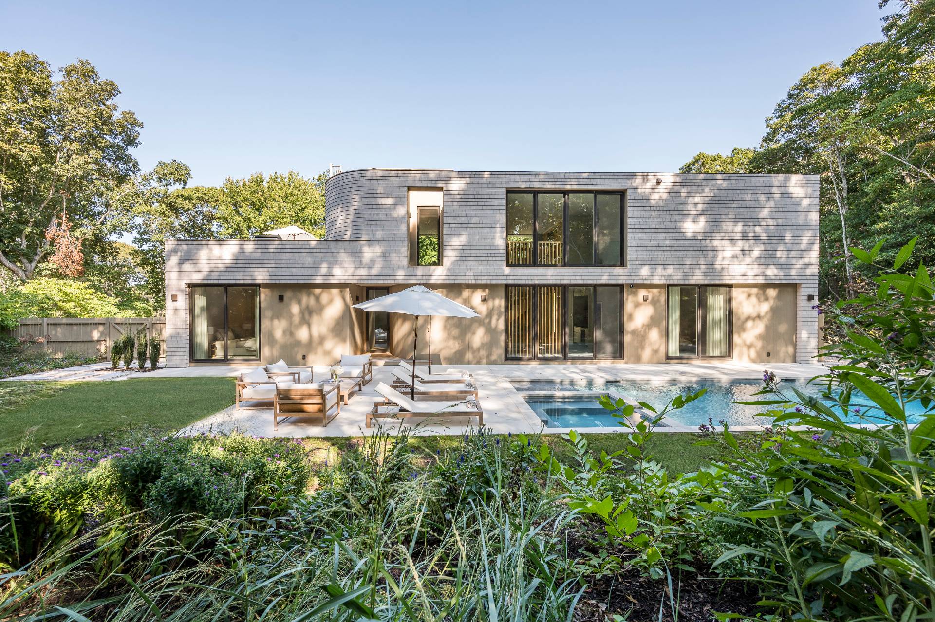 232 Kings Point Road East Hampton, NY 11937 - Photo 31 of 37 a front view of a house with a yard table and chairs