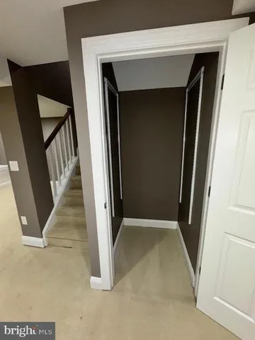 an empty room with a chandelier fan and windows