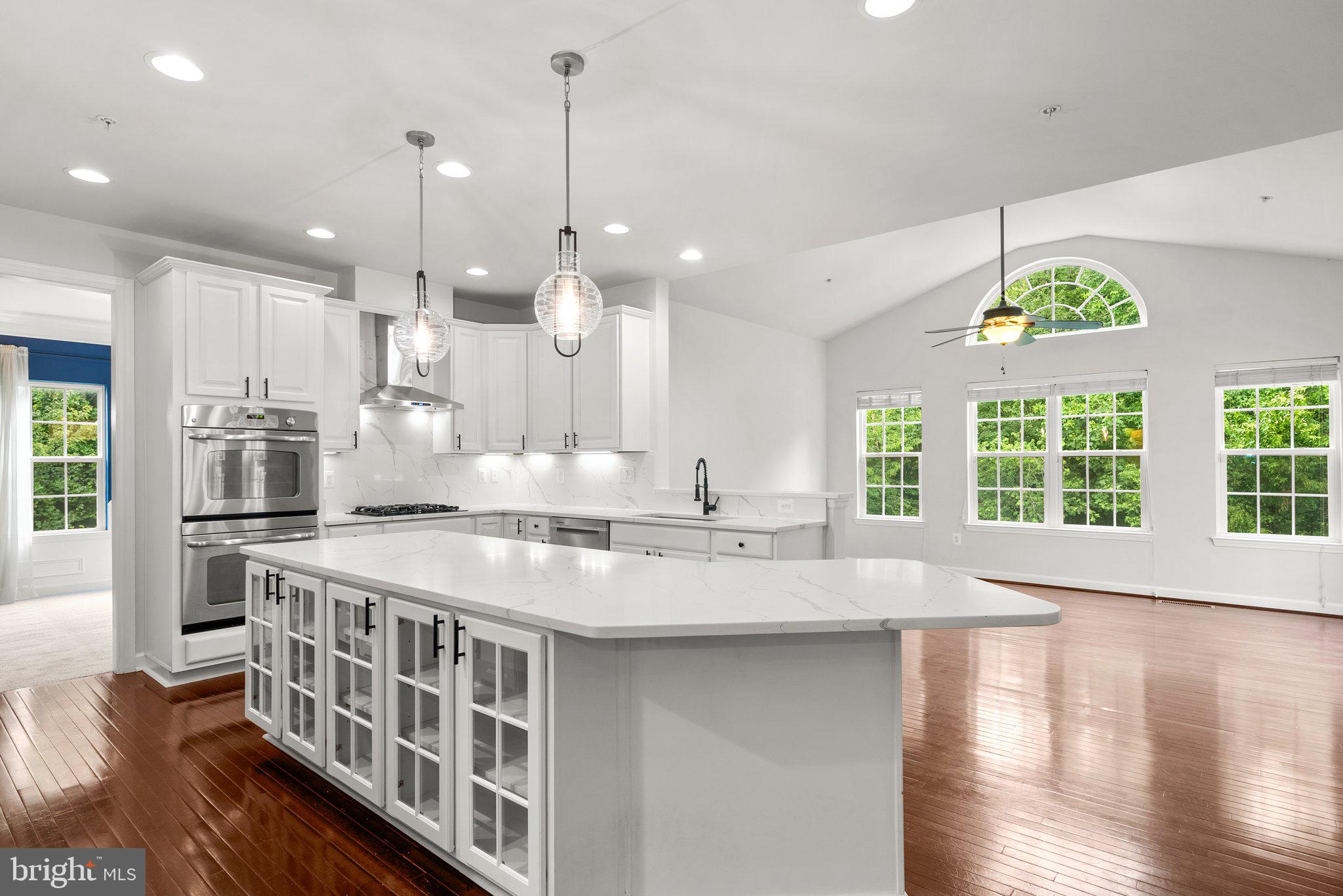 8304 Cedarview Court Clinton, MD 20735 - Photo 14 of 39 a large kitchen with stainless steel appliances kitchen island a large counter tops and a wooden floor