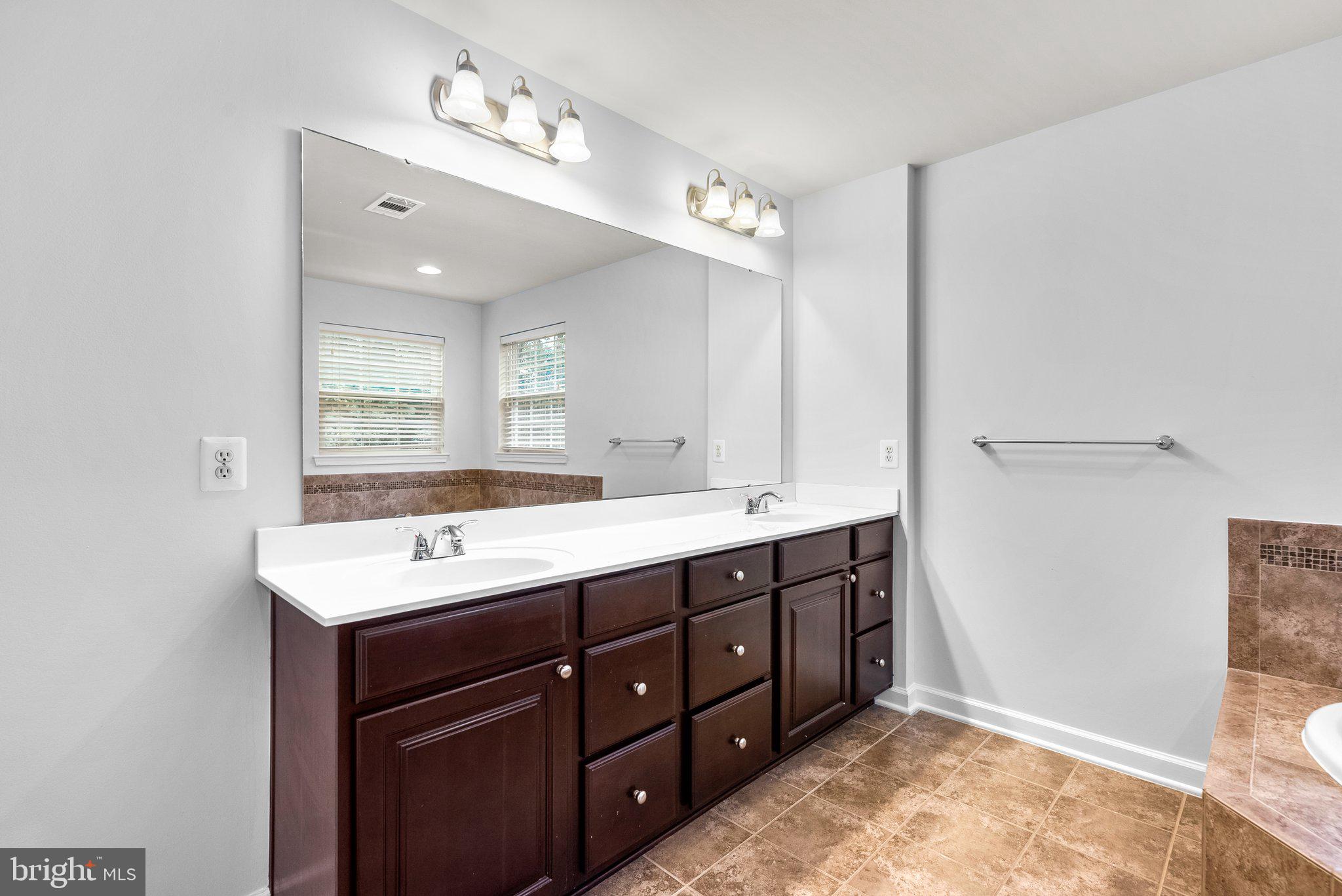 8304 Cedarview Court Clinton, MD 20735 - Photo 22 of 39 a spacious bathroom with a double vanity sink a mirror and a shower