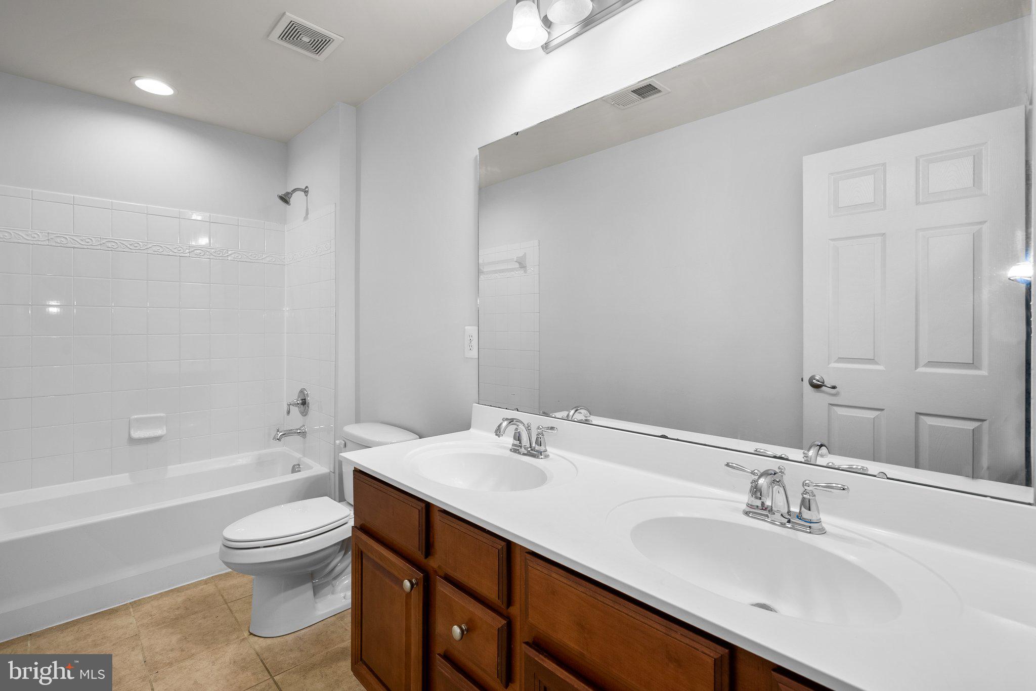 8304 Cedarview Court Clinton, MD 20735 - Photo 24 of 39 a bathroom with a toilet a sink a bathtub and a mirror