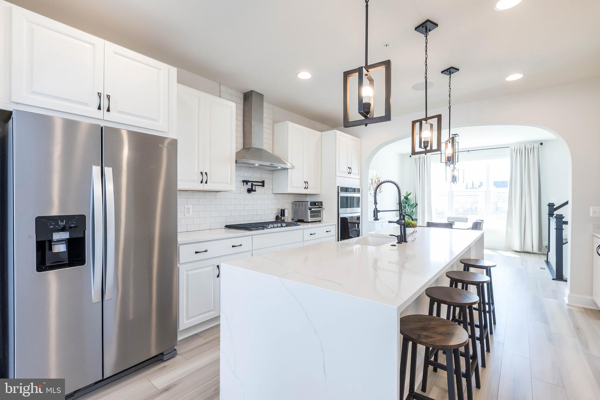 1096 Holden Road Frederick, MD 21701 - Photo 6 of 51 a kitchen with kitchen island a refrigerator a stove a sink and chairs