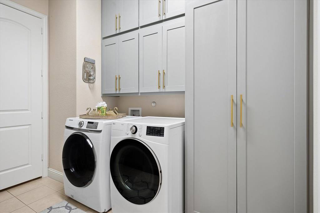 8268 Kara Creek Road Frisco, TX 75036 - Photo 24 of 31 Laundry area featuring floor-to-ceiling cabinetry, overhead storage, and light-toned walls