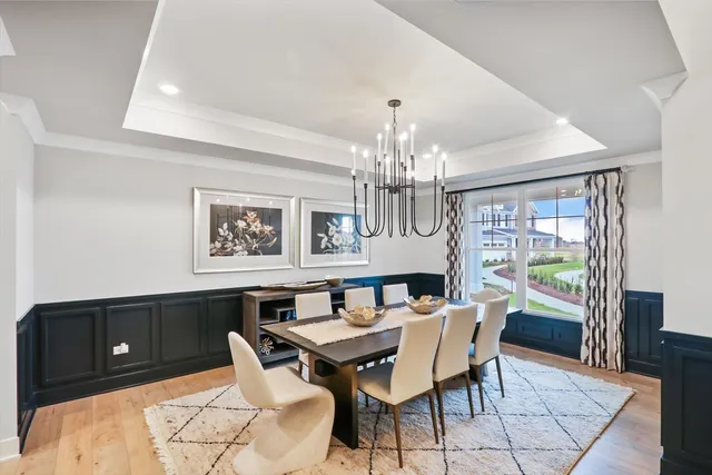 a view of a dining room with furniture a chandelier and wooden floor