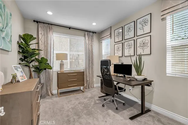 a view of a workspace with furniture and a window