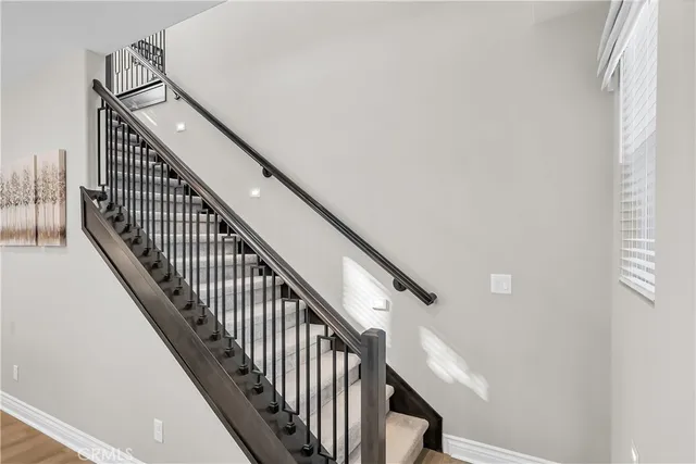 a view of staircase with railing and white walls