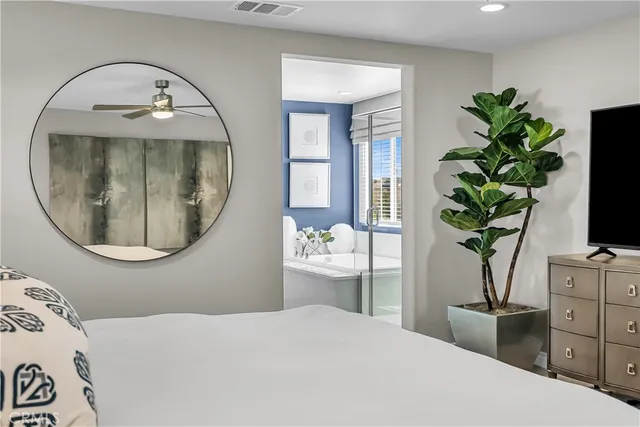 a bedroom with a bed and a potted plant