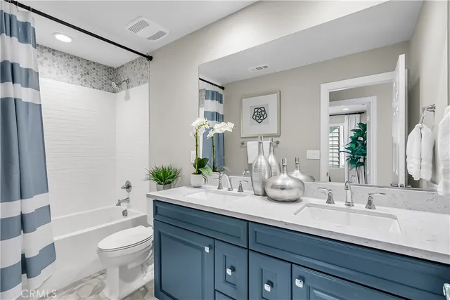 a bathroom with a double vanity sink toilet and shower