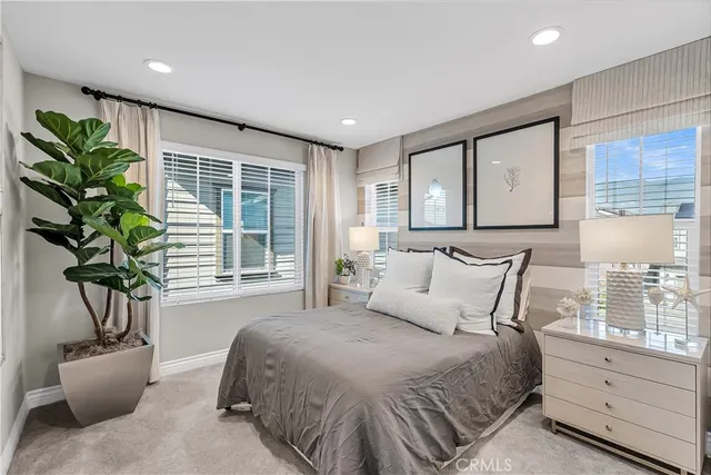 a bedroom with a large bed and a potted plant