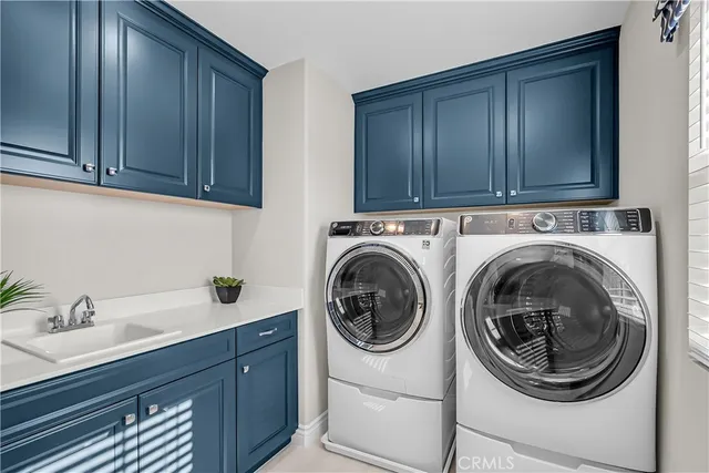 a utility room with sink dryer and washer
