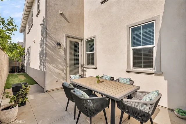 a backyard of a house with table and chairs