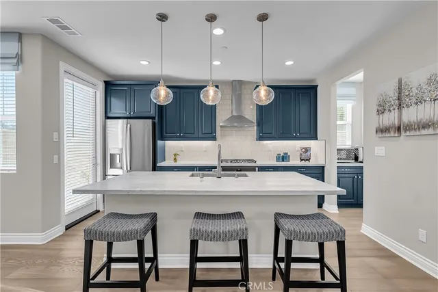 a kitchen with kitchen island a dining table chairs and white cabinets