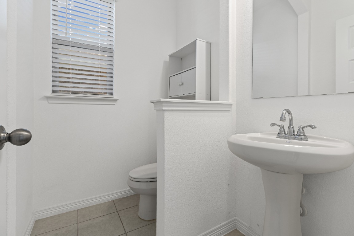 20520 Carries Ranch Road Pflugerville, TX 78660 - Photo 15 of 32 a bathroom with a sink a toilet and mirror