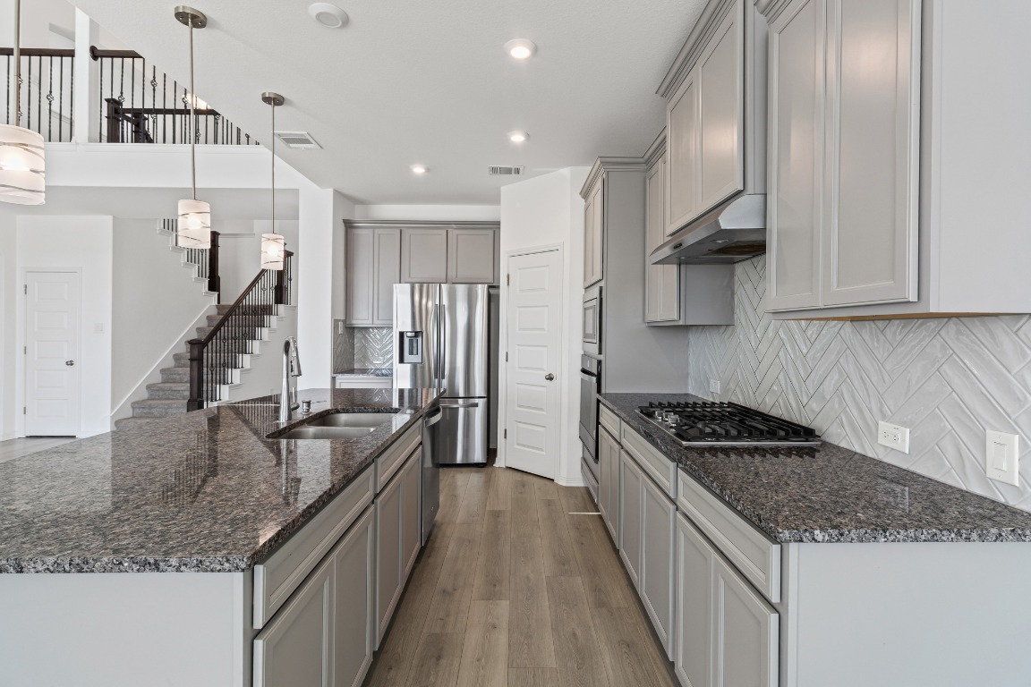 20520 Carries Ranch Road Pflugerville, TX 78660 - Photo 7 of 32 a kitchen with kitchen island granite countertop lots of counter top space