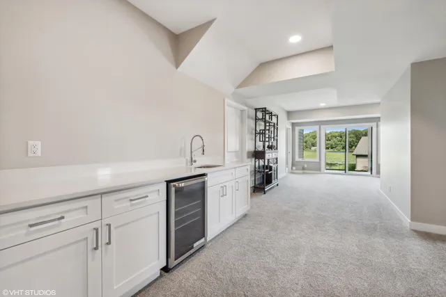 a large white kitchen with sink and white cabinets