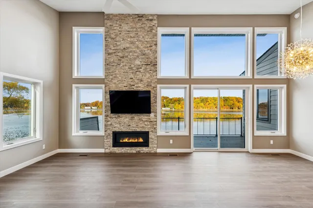 an empty room with furniture wooden floor fire place and windows