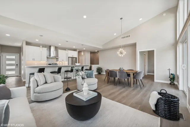 a living room with furniture kitchen view and a large window
