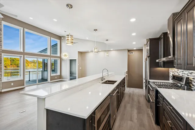 a kitchen with stainless steel appliances granite countertop a sink a stove and a refrigerator