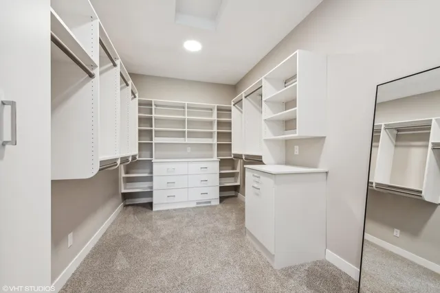 a view of walk in closet with clothes and shoes