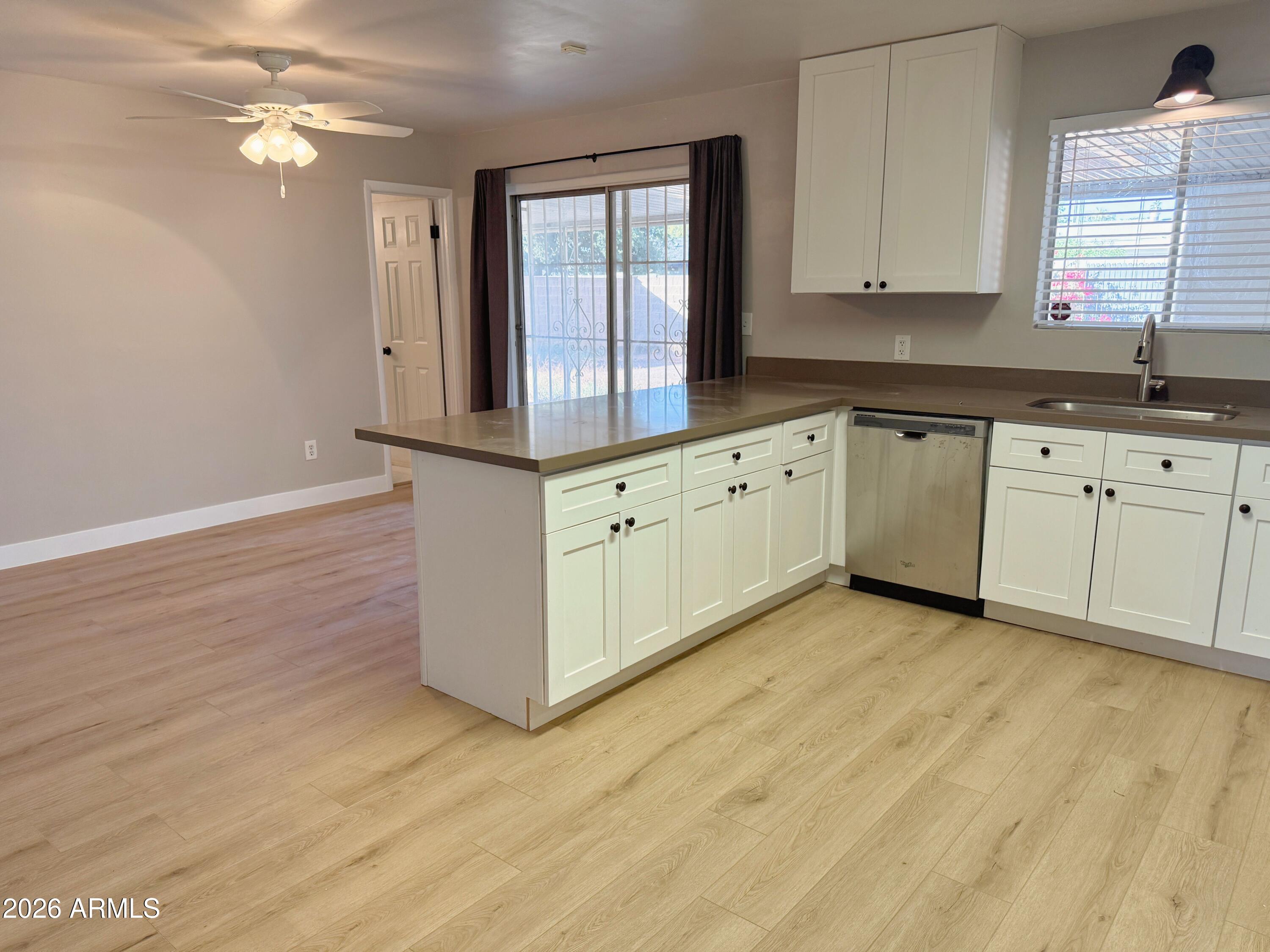 1220 West Romo Jones Street Tempe, AZ 85281 - Photo 6 of 26 a kitchen with granite countertop white cabinets white appliances and a wide window